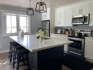 a kitchen with a counter with a vase of flowers on it at Sunrise net cottage in Kawartha Lakes