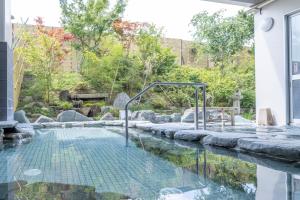 a swimming pool in the middle of a house with a garden at Hill Hotel Sunpia Iga in Iga