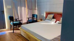 a bedroom with two chairs and a bed and a window at The apricot house in Leh