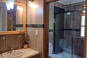 a bathroom with a sink and a glass shower at La Pradera, Casa de Campo Privada, 2-14 Personas - Cambio Oficial in Tarija