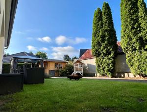 a house with a yard with trees and a swing at Casa Edelsita in Hoppegarten