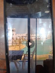 een glazen raam met een tafel en uitzicht op een stad bij فوكا باى in Marsa Matruh