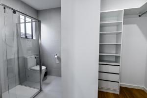 a bathroom with a toilet and a glass shower at Luxury home away from home in Mickleham +26 photos