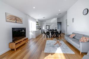 a living room with a couch and a tv at Luxury home away from home in Mickleham