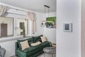un divano verde in un soggiorno con una finestra di Apartment Gamsblick a Hinterstoder