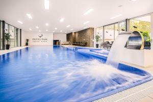 ein Schwimmbad mit Wasserrutsche in einer Hotellobby in der Unterkunft Hotel Park in Piešťany + 69 Fotos