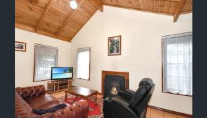 a living room with leather furniture and a fireplace at Mountainside Villas Halls Gap in Halls Gap