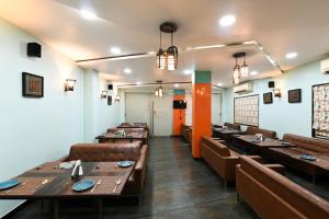 a dining room with wooden tables and brown chairs at Hotel The Sudesh in Raipur
