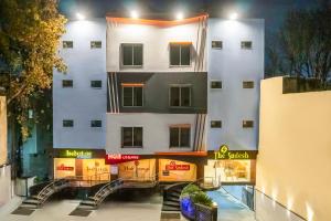 a white building with signs in front of it at Hotel The Sudesh in Raipur