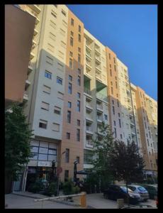 a tall apartment building with cars parked in front of it at Design Prishtina Apartment 1 in Pristina