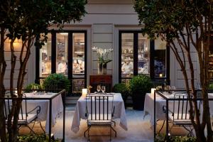 a restaurant with two tables and chairs and trees at Mandarin Oriental, Milan in Milan