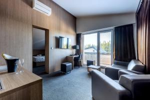 pokój hotelowy z kanapą i dużym oknem w obiekcie Hotel Jezerka w mieście Seč