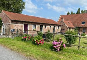 a house with flowers on the side of the road at la ferme au bois dormant in Wemaers-Cappel