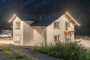 una casa bianca con luci sul lato di Apartment Gamsblick a Hinterstoder
