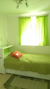 a bedroom with a green bed with a window at Bergadler in Iselsberg
