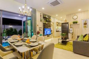 Un comedor y una sala de estar con mesa y sillas. en Pool Villa No 10 by Duangtham, en Ban Khlong Haeng