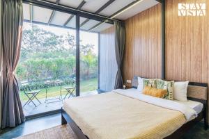 ナーシクにあるStayVista's Celeste Villa - Hill-View Retreat with Infinity Poolの大きなベッドと大きな窓のある寝室 +17枚の写真