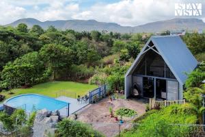 ナーシクにあるStayVista's Celeste Villa - Hill-View Retreat with Infinity Poolのプール付きの家の航空写真