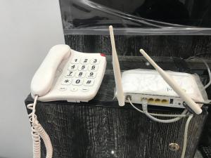 a white phone sitting on top of a shelf at Guest House in Jhelum