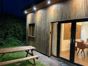 ShanagarryBeach Cabin, Cork, near Ballymaloe House & Garryvoe Hotels的一座带长凳和桌子的小建筑