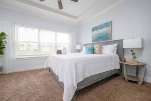 a white bedroom with a large bed and a window at Be A Nomad - Coastal Retreat 100 yds to Beach in Jacksonville Beach