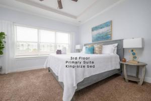 a bedroom with a bed with a white bedspread and a window at Be A Nomad - Coastal Retreat 100 yds to Beach in Jacksonville Beach