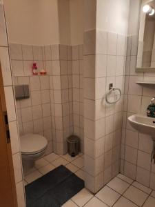 a bathroom with a toilet and a sink at Ferienwohnung Mittelpunkt in Schortens +17 photos