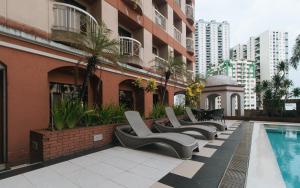 a row of lounge chairs next to a swimming pool at Torre Venezia Suites in Manila