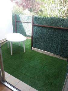 a white table and a bench on top of green grass at T2 rez de jardin Saint Pierre la mer in Fleury