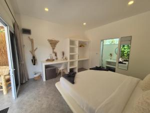 a bedroom with a large white bed and a desk at Sea Love Beach Bar & Bungalows in Ban Tai