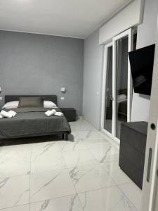 a bedroom with a bed and a tiled floor at Giovi's Apartments ROOM in Castellammare di Stabia