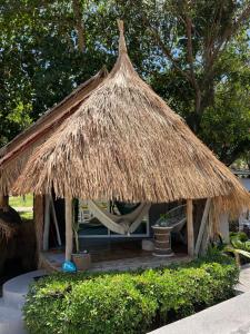 a hut with a hammock and a straw roof at Sea Love Beach Bar & Bungalows in Ban Tai