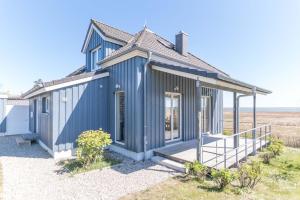 a blue tiny house with a porch and stairs at Haus NÖCK in Wustrow