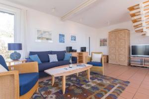 a living room with a blue couch and a tv at Haus NÖCK in Wustrow