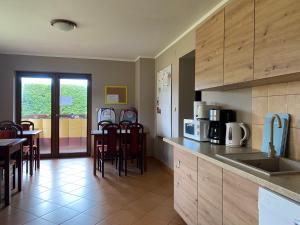 a kitchen with wooden cabinets and a table and chairs at Żółta Chata in Władysławowo