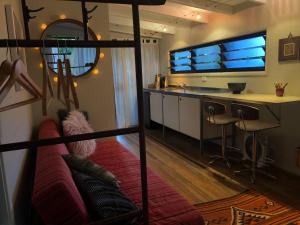 a living room with a couch and a kitchen at Boatshed tallows beachside in Byron Bay