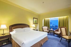 a hotel room with a large bed and a window at Waterfront Cebu City Hotel & Casino in Cebu City