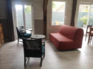 a living room with a couch and a table and chairs at L'atypique in Lignières