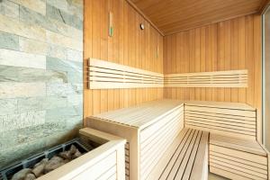 una sauna con pareti rivestite in legno e scaffali in legno di Klifowa Resort Apartment SPA & Fitness Near the beach in Rewal by Renters Prestige a Rewal Altre 42 foto