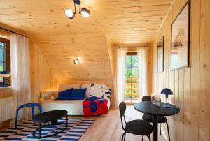 a room with a couch and two tables and chairs at Apartamenty & Pokoje MyWy in Zakopane