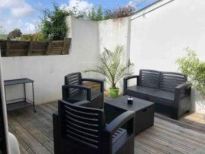 a patio with two chairs and a bench and a table at Maison de ville conviviale avec terrasse in Lanester