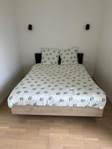 a bed in a small room with a white wall at Maison de ville conviviale avec terrasse in Lanester