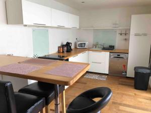 a kitchen with white cabinets and a table and chairs at Maison de ville conviviale avec terrasse in Lanester +3 photos