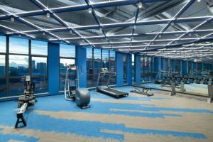 a gym with treadmills and machines in a building at 东莞大朗希尔顿欢朋酒店 in Huangcaolang