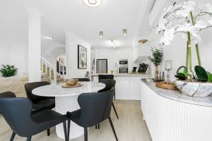 a kitchen and dining room with a table and chairs at Shearwater Luxury in Coffs Harbour