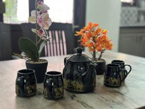 a table with a tea pot and four plants on it at PlushStays Service Apartment in Madurai
