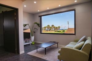 a living room with a couch and a table and a window at Stay Handol in Seogwipo