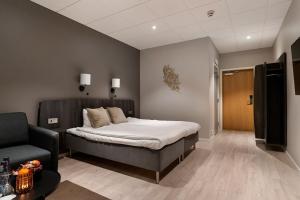 una camera con un letto e una sedia di Quality Hotel Vänersborg a Vänersborg