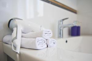 a pile of towels sitting on top of a bathroom counter at Mare et Silva Apartment Dubrovnik in Dubrovnik +5 photos