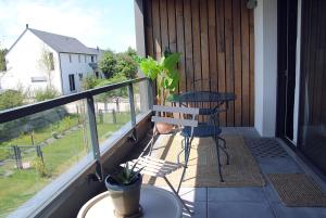 a balcony with a table and a chair on a porch at Blue Sand - Appartement cosy-neuf à 500 m du bourg in Saint-Philibert